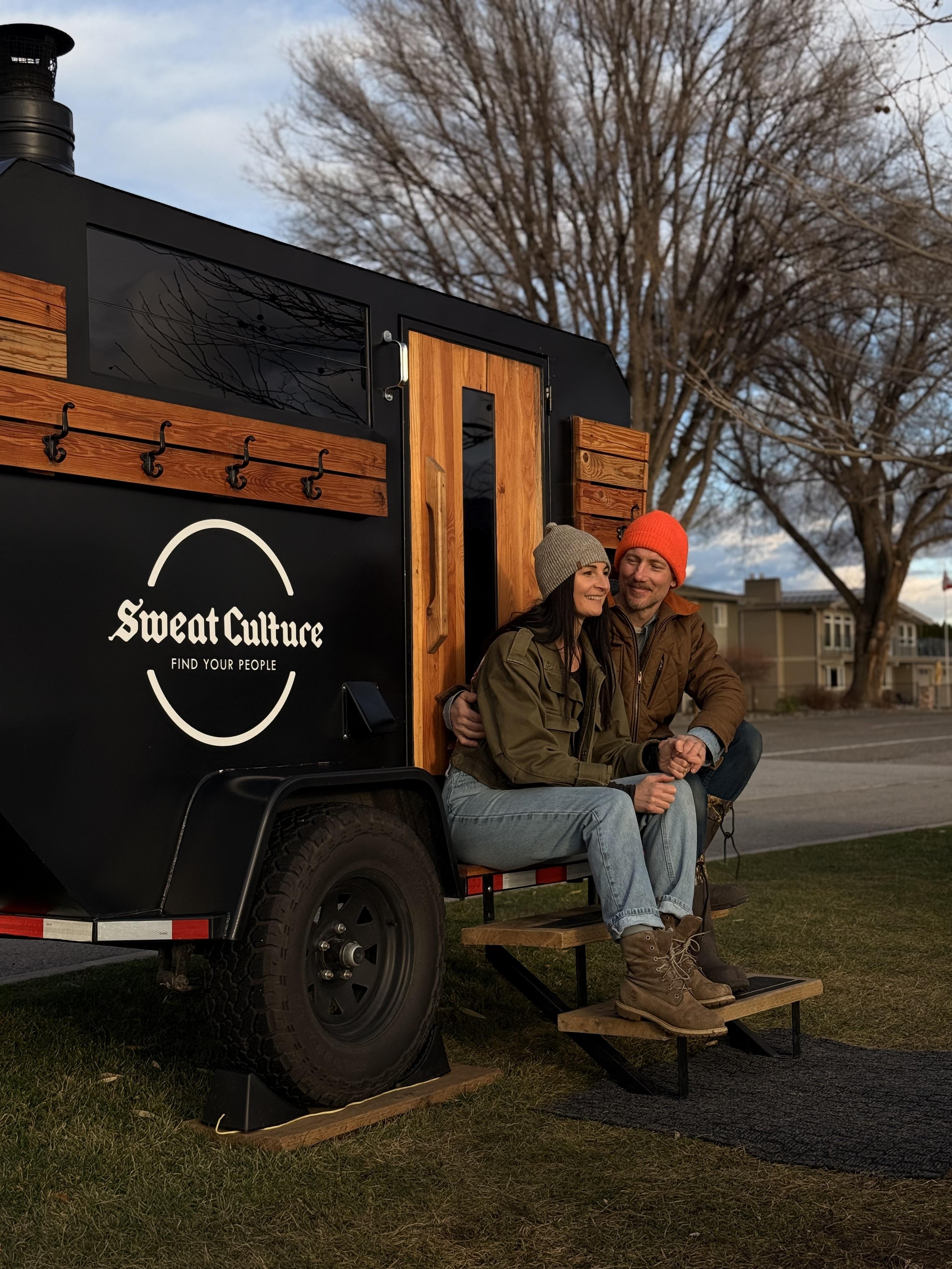 Nina and Braden, founders of Sweat Culture, sitting in front of the adventure trailer sauna in Peachland, BC