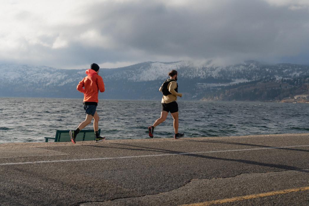 Two runners running along the Okanagan Lake waterfront in Peachland during the Sweat Culture run club in winter, sauna and run combo session
